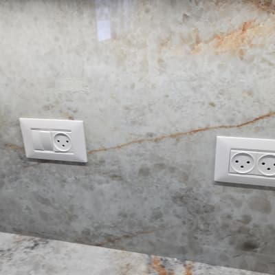 שני שקעי חשמל בקיר שיש אפור