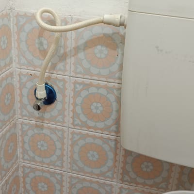 אסלה עם צינור מים מחובר לקיר