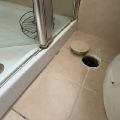 מקלחון עם דלת זכוכית ורצפת אריחים