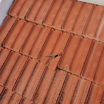 רעפים כתומים על גג עם רעף שבור