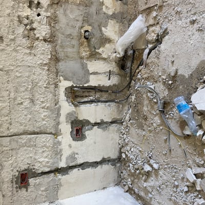 קיר עם צינורות חשופים ועבודות שיפוץ