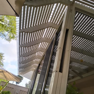 פרגולה מעץ עם קורות אופקיות וגג שקוף