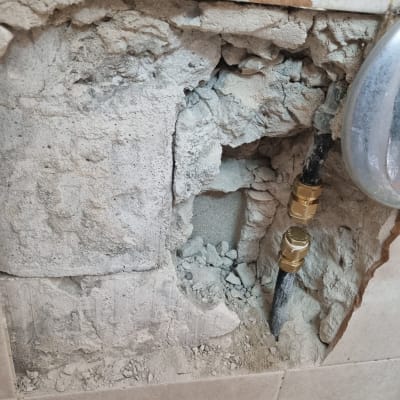 צינור מים חשוף בקיר עם חיבורים חשופים