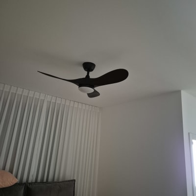 מאוורר תקרה בחדר שינה עם וילונות ומיטה