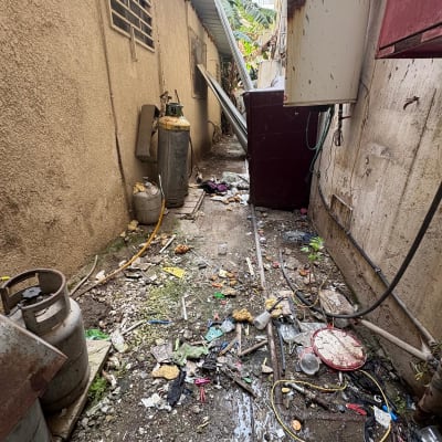 פסולת ובלגן בחצר אחורית עם בלוני גז וצינורות
