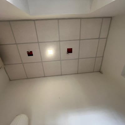 תקרת גבס עם תאורה מרובעת ושני פתחים אדומים