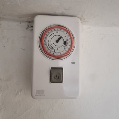 טיימר חשמלי עם כפתור הפעלה על קיר