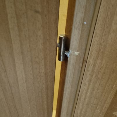 ציר מתכת בדלת עץ חומה פתוחה מעט