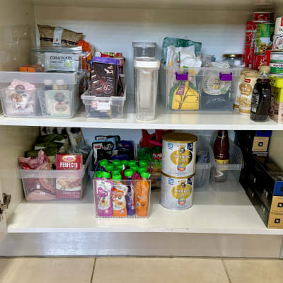 מזווה מאורגן עם קופסאות פלסטיק ומוצרי מזון שונים