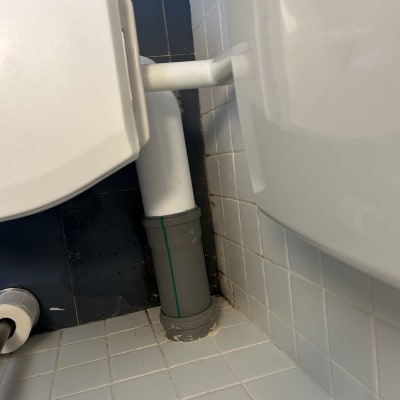 צינור פלסטיק מחובר לאסלה בחדר אמבטיה