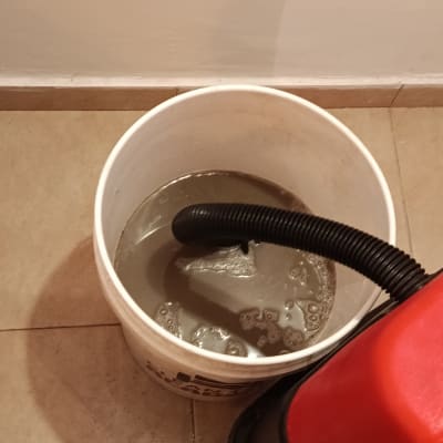 דלי עם מים מלוכלכים וצינור שאיבה