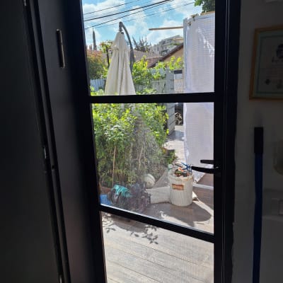 דלת אלומיניום עם נוף לגינה וכלי עבודה