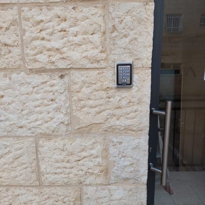 לוח מקשים של אינטרקום מותקן על קיר אבן