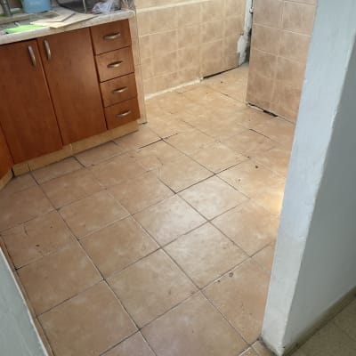 מטבח עם אריחים שבורים ופינת קיר מתקלפת