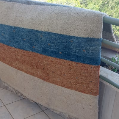 שטיח תלוי על מעקה מרפסת לניקוי