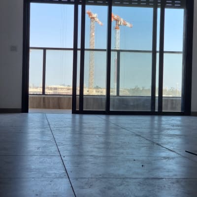 רצפה נקייה עם חלון גדול ומנופים ברקע