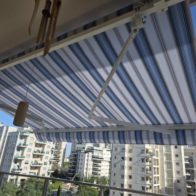 סוכך פסים כחול ולבן על מרפסת