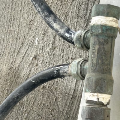 צינור ומחבר מתכת על רקע בטון