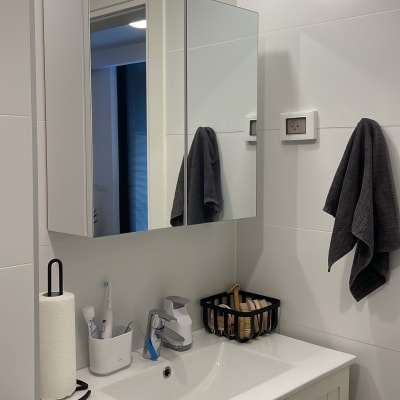 מראה עם תאורה, כיור וברז בחדר אמבטיה