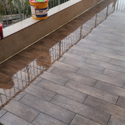 מרפסת עם דלי צבע ומברשת לאיטום רצפה רטובה