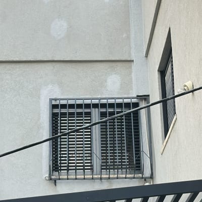 חלון עם סורגים על קיר חיצוני של בניין