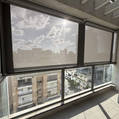 מרפסת עם סוככים שקופים ונוף עירוני
