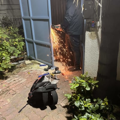 אדם חותך דלת מתכת עם דיסק חשמלי