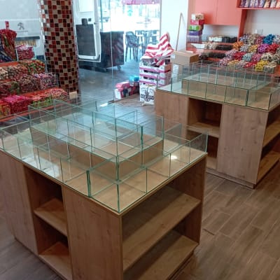 שולחנות עץ עם מחיצות זכוכית בחנות ממתקים
