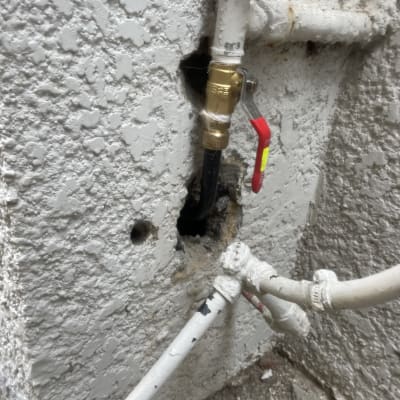 צינור עם ברז ומחברים בקיר בטון