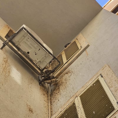 מזגן עם לכלוך יונים על קיר חיצוני