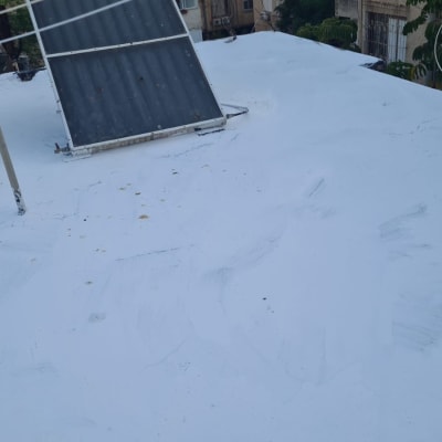 גג אטום בצבע לבן עם לוחות סולאריים