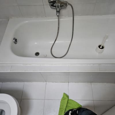 אמבטיה נקייה עם מגבת ירוקה על הרצפה