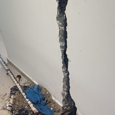 קיר עם חור ותשתית צנרת חשופה