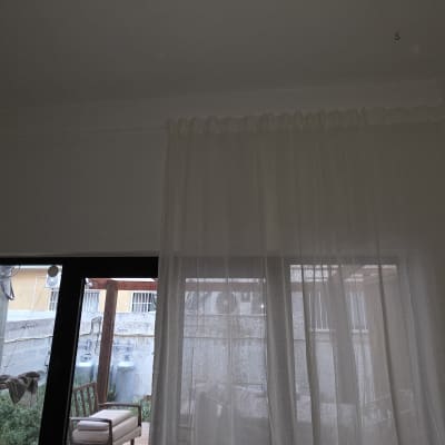וילון לבן ליד חלון עם נוף חיצוני