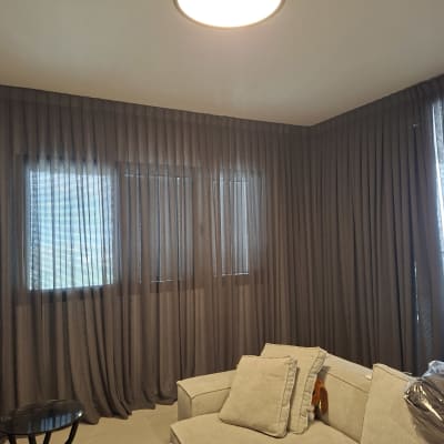 סלון עם וילונות כהים וספה בהירה