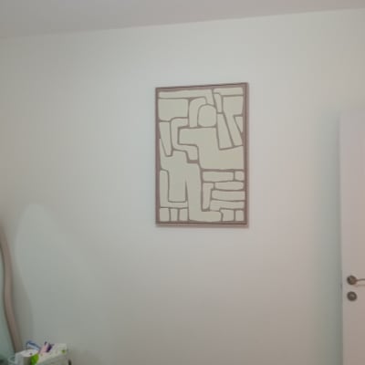 חדר עם תמונה מופשטת על הקיר ומיטה