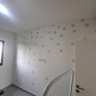 קיר עם טפט נקודות צבעוניות בחדר ריק