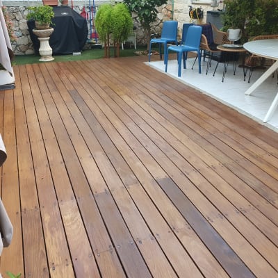 דק עץ חום בגינה עם כיסאות ושולחן