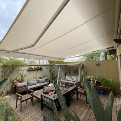 סוכך בד לבן תלוי מעל מרפסת עץ