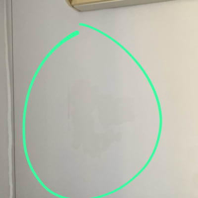 מזגן מותקן על קיר לבן עם כתם לחות