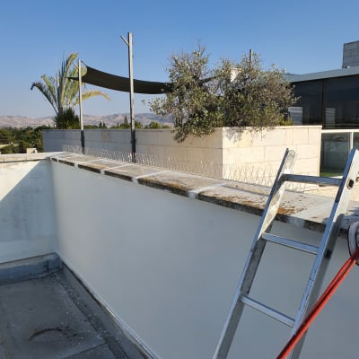 סולם וכלי עבודה על גג עם קיר אטום