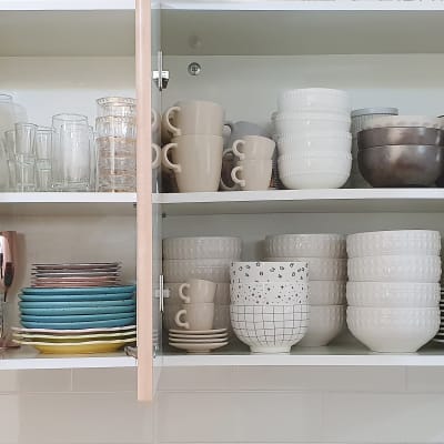 ארון מטבח עם כוסות, צלחות וקערות מסודרים