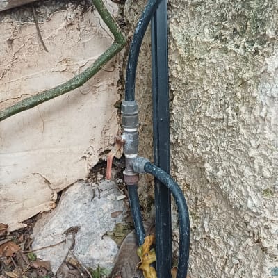 צינור מים מחובר לקיר חיצוני עם ברז