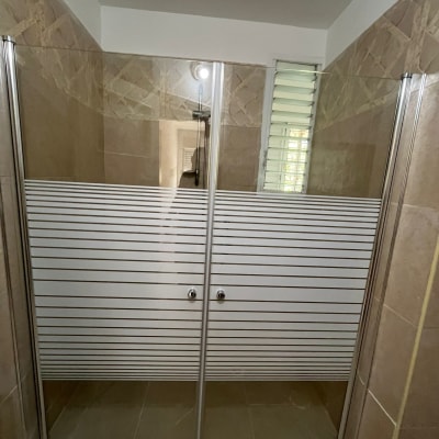 דלתות זכוכית במקלחת עם פסי מתכת אופקיים