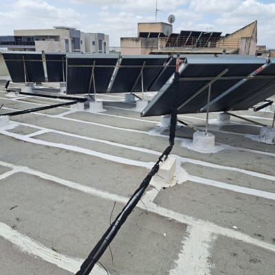 איטום גג עם לוחות סולאריים וצינורות מחוברים