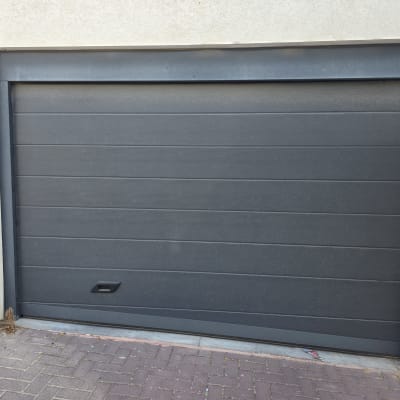 שער חשמלי אפור עם לוח מקשים בצד ימין