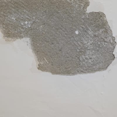 קיר עם טיח מתקלף וחשיפת בטון