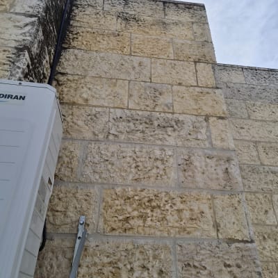 קיר אבן עם מזגן מותקן בצד