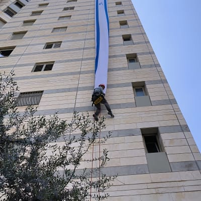 אדם מטפס על בניין גבוה עם חבל בטיחות