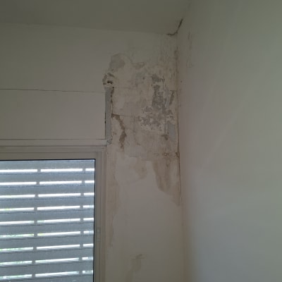קיר עם נזקי רטיבות ליד חלון